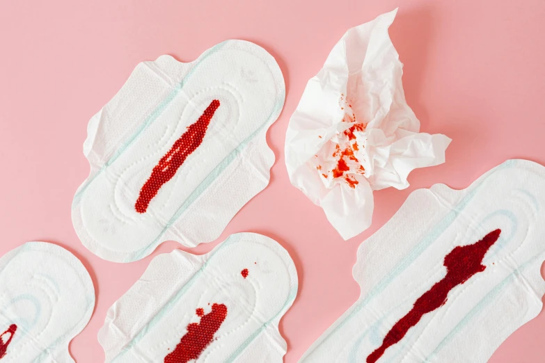 a bunch of sanitary pads sitting on top of a pink surface, by Julia Pishtar, happening, blood around the lips, white and red color scheme, close-up product photo, bloody scene