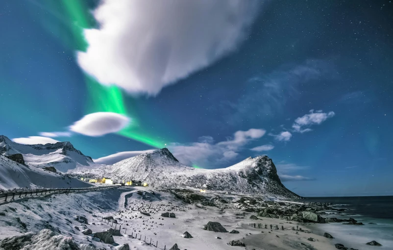 a train traveling past a mountain covered in snow, by Sven Nordqvist, pexels contest winner, surrealism, aurora in the sky, moonbow, mountains and ocean, conde nast traveler photo