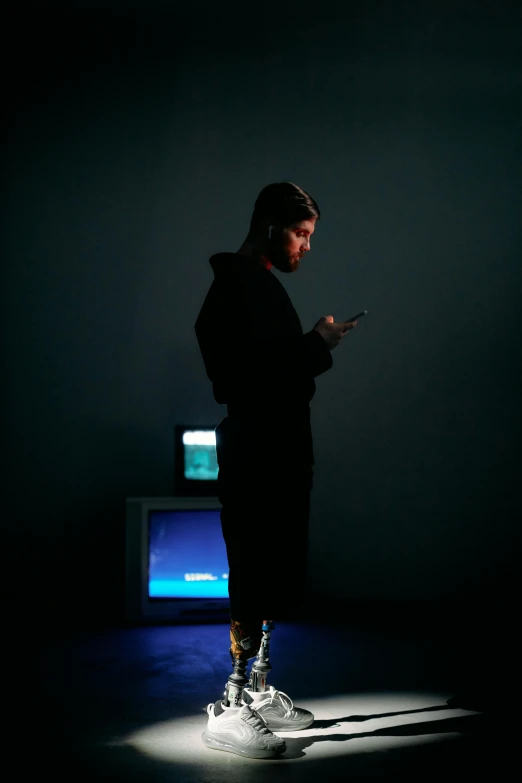 a man standing in a dark room looking at his cell phone, a hologram, by Paul Bird, yung lean, portrait full body, vhs style, steve wozniak