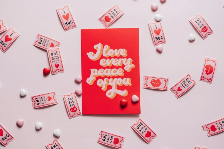 a red card sitting on top of a pile of candy, by Julia Pishtar, pexels contest winner, private press, i love you, risograph poster, love peace and unity, flowing lettering