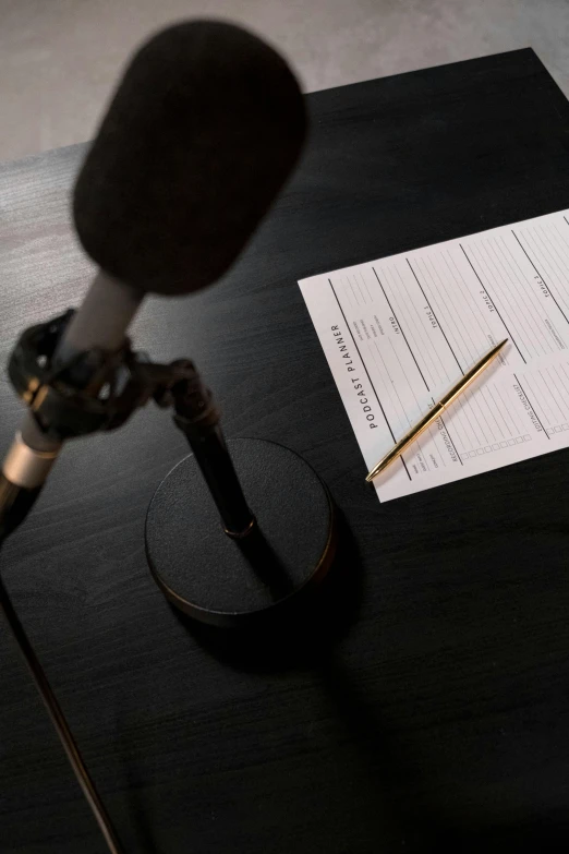 a microphone sitting on top of a table next to a piece of paper, thumbnail, episode, multiple stories, forms