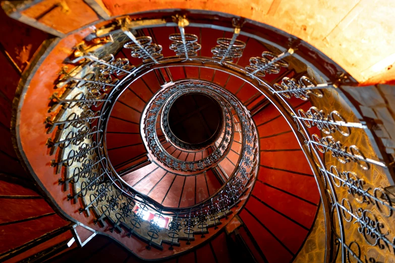 a spiral staircase leading to the top of a building, an album cover, by Konrad Witz, pexels contest winner, art nouveau, red and brown color scheme, fish eye view, trip to legnica, cyber copper spiral decorations