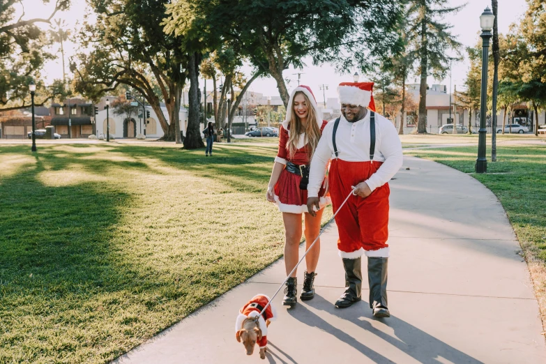 a man and a woman walking a dog on a leash, a photo, by Julia Pishtar, pexels, santa clause, teenage vanessa morgan, full costume, southern california