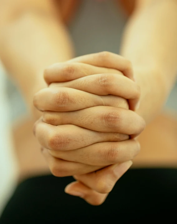 a close up of a person holding their hands, square, pray, non-binary, asian male