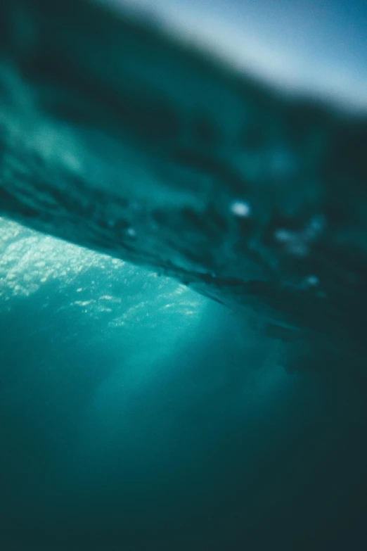 an underwater view of the surface of the water, a picture, by Jacob Toorenvliet, unsplash, inside the curl of a wave, teal color graded, afternoon light, icy