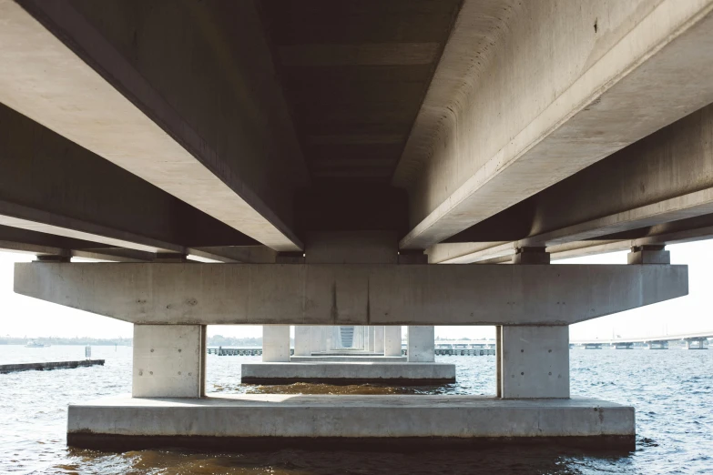 the underside of a bridge over a body of water, unsplash, brutalism, ignant, sitting down, multiple stories, 1980s photo