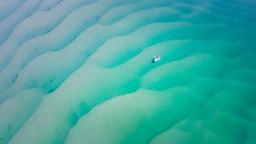 a small boat floating on top of a body of water, by Jessie Algie, pexels contest winner, australian beach, top - down photo, teals, cornwall