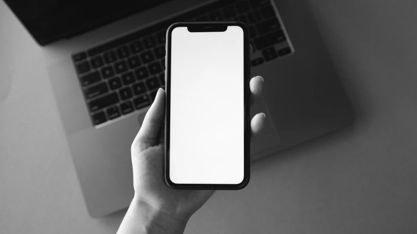 a person holding a phone in front of a laptop, a black and white photo, pexels, computer art, full view blank background, square, iphone 15 background, black border