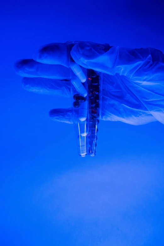 a person holding a syet in their hand, a microscopic photo, conceptual art, test tubes, cold blue lighting, ap news, 15081959 21121991 01012000 4k