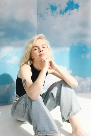 a woman sitting on top of a white floor, an album cover, inspired by Louisa Matthíasdóttir, trending on pexels, pale hair, cumulus tattoos, wearing casual clothes, portrait photo of a backdrop