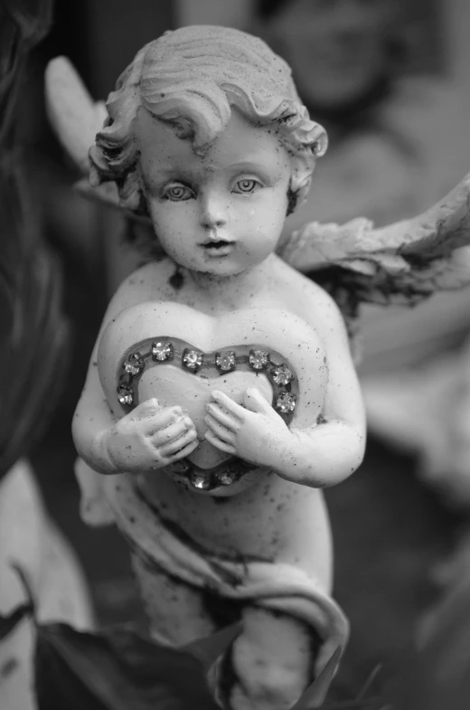 a statue of an angel holding a heart, a statue, inspired by Correggio, pexels contest winner, black and white old photo, made of wax and metal, (heart), eyes