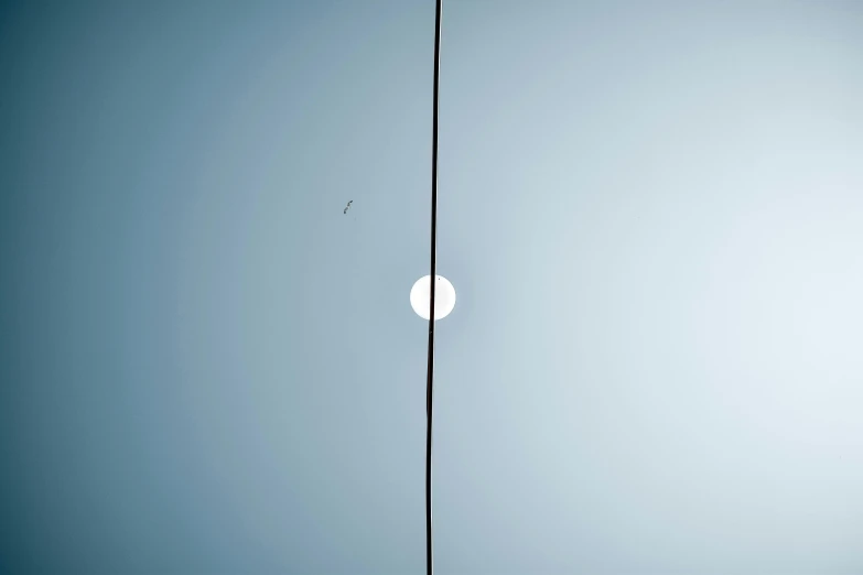 a large jetliner flying through a blue sky, inspired by Jan Rustem, minimalism, fishing pole, two suns, shot on hasselblad, white moon