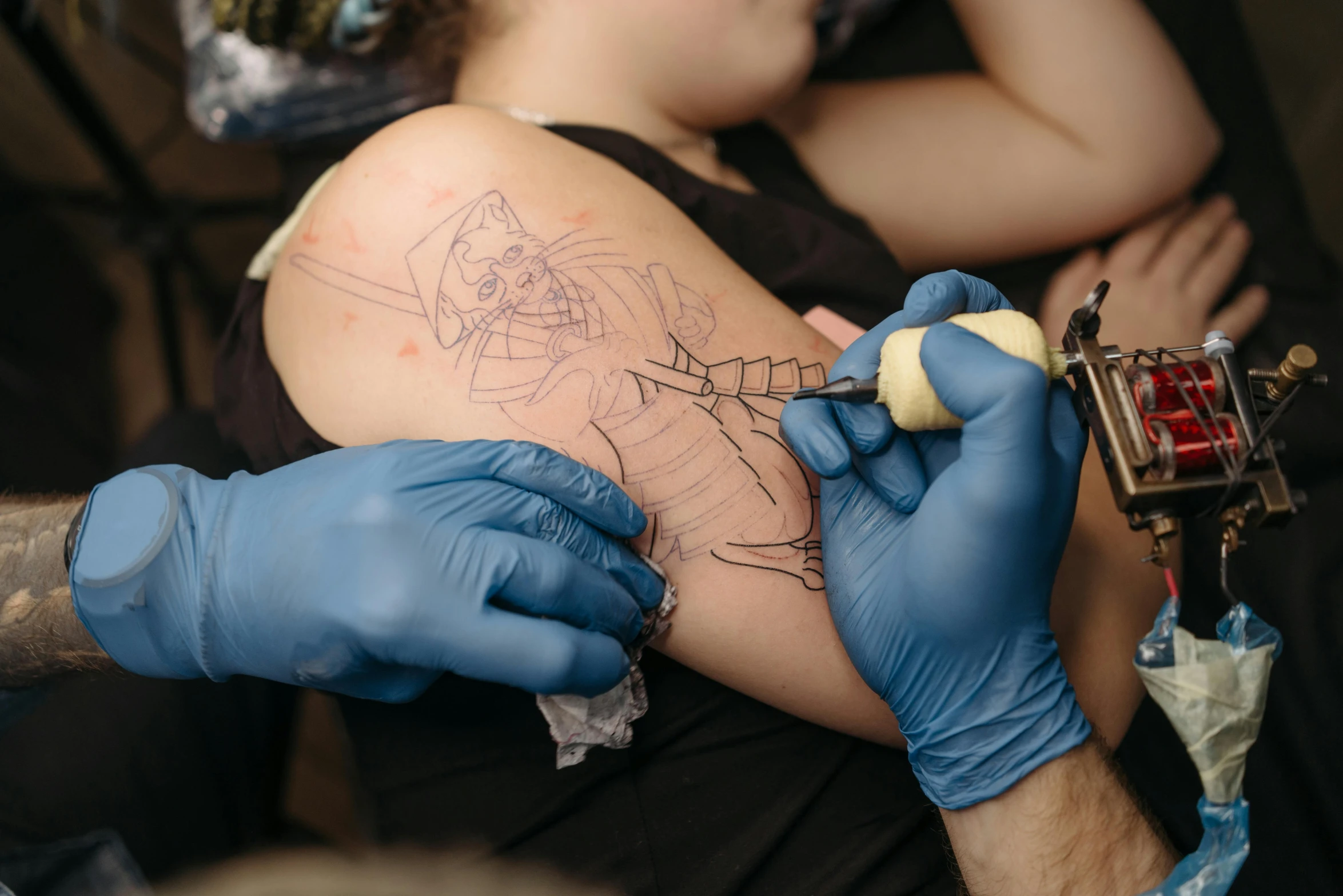 a man getting a tattoo on his arm, a tattoo, by Adam Marczyński, fan favorite, outlined art, body-horror, blue ink