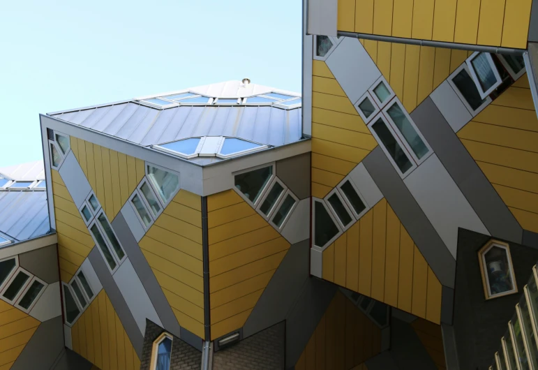 a couple of buildings that are next to each other, inspired by Karel Dujardin, unsplash, modular constructivism, silver and yellow color scheme, lots of windows, dutch angle, a rubik's cube