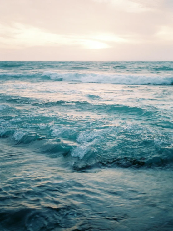 a man standing on top of a surfboard in the ocean, inspired by Elsa Bleda, trending on unsplash, renaissance, rippling fabric of reality, a photo of the ocean, glistening seafoam, wavy water