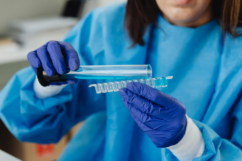 a close up of a person wearing gloves holding a tube, medical lab, wearing a plastic blue dress, avatar image, healthcare