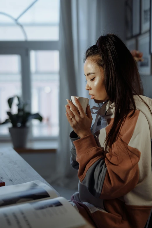 a woman sitting at a table with a cup of coffee, trending on pexels, hyperrealism, young asian girl, wearing robe, sweat, profile image