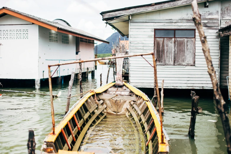 a boat that is sitting in the water, inspired by Steve McCurry, pexels contest winner, houses on stilts, tan, malaysian, graphic print