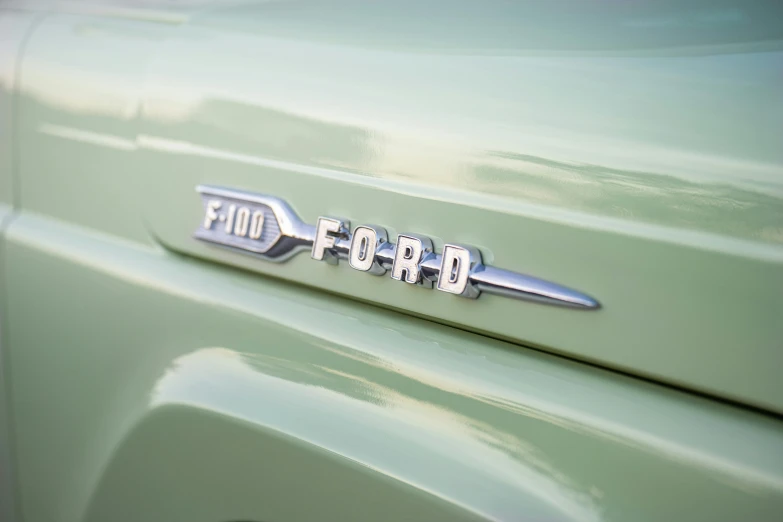 a close up of the emblem on a green truck, by Carey Morris, trending on unsplash, ford, 1959, pastel', restomod