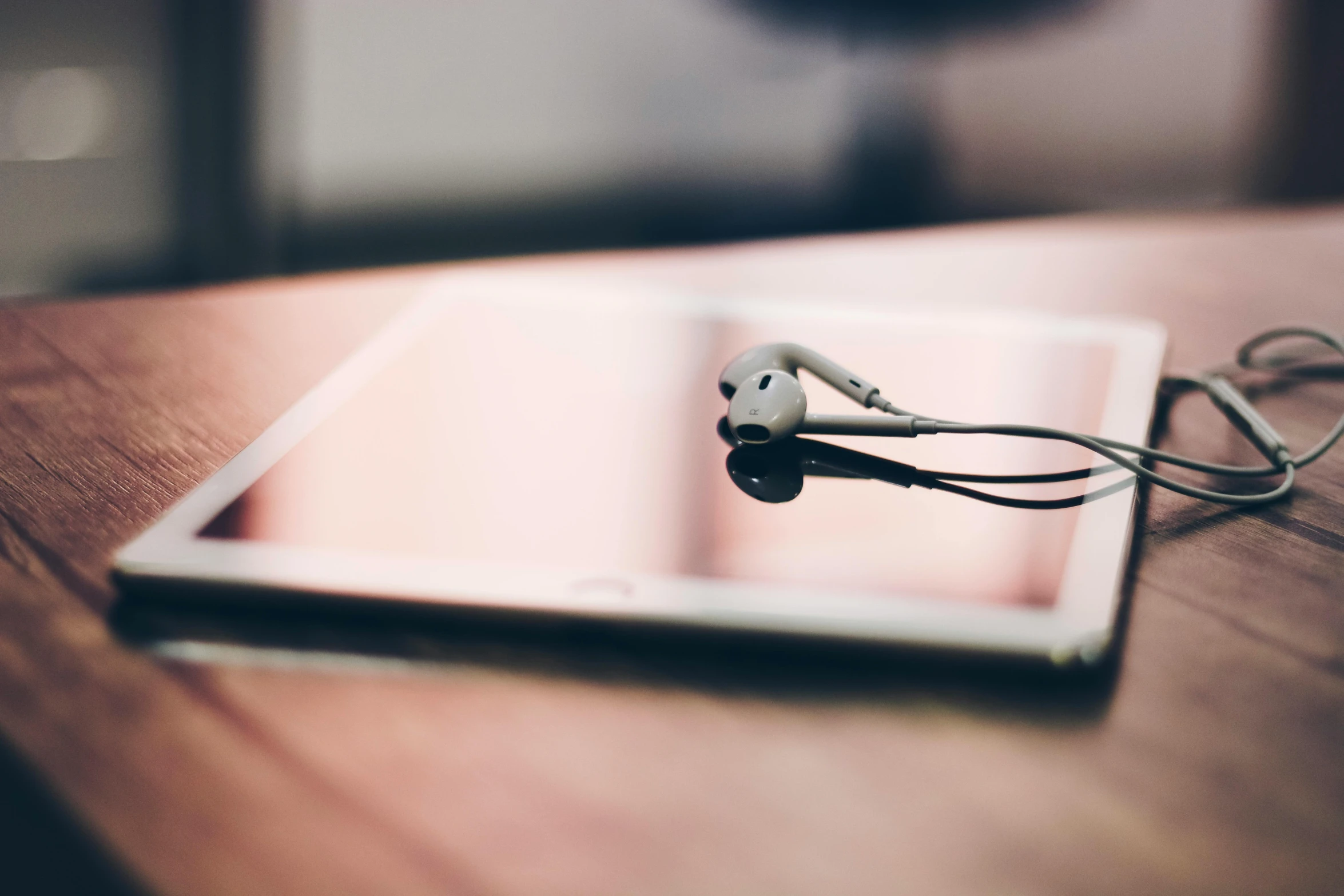 a tablet computer sitting on top of a wooden table, an album cover, trending on pexels, bronze headset, reflection, mundane, sharp focus »