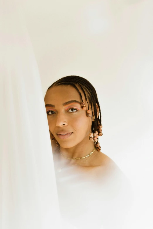 a woman standing in front of a white curtain, an album cover, inspired by Sophia Beale, trending on pexels, renaissance, cornrows braids, veils and jewels, sydney sweeney, ashteroth