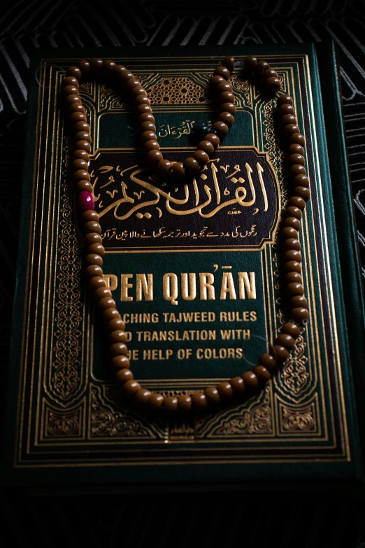 a close up of a book with a rosary on it, hurufiyya, cyberpunk mosque interior, 256x256, kuala lumpur, unsplash photo contest winner