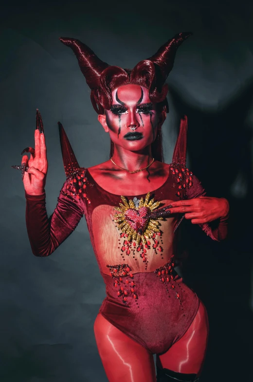 a woman in a devil costume posing for a picture, an album cover, inspired by Ignacy Witkiewicz, transgressive art, bodypaint, 2019 trending photo, queer woman, hearts