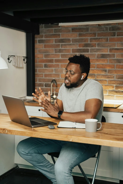 a man sitting at a table in front of a laptop computer, trending on pexels, renaissance, giving a speech, black man, standing straight, full product shot