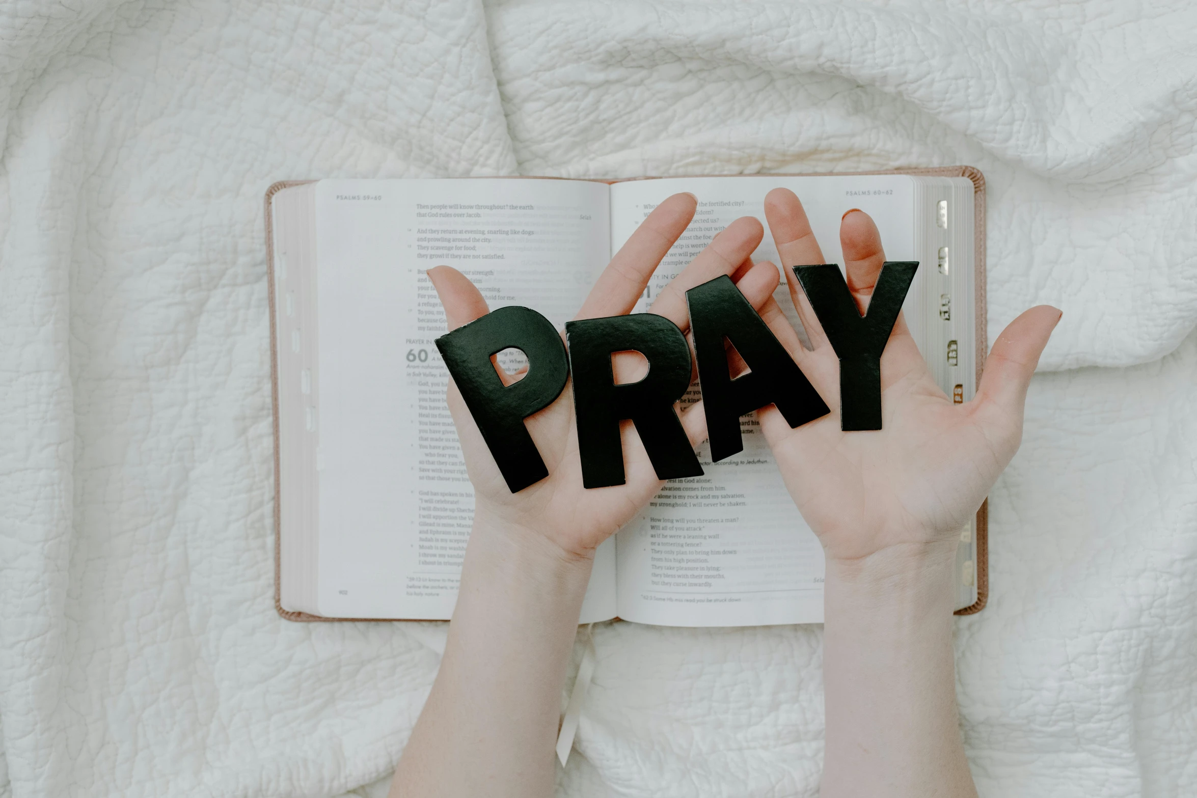 a person holding the word pray in front of an open book, by Julia Pishtar, pexels, avatar image, background image, instagram post, 70s photo
