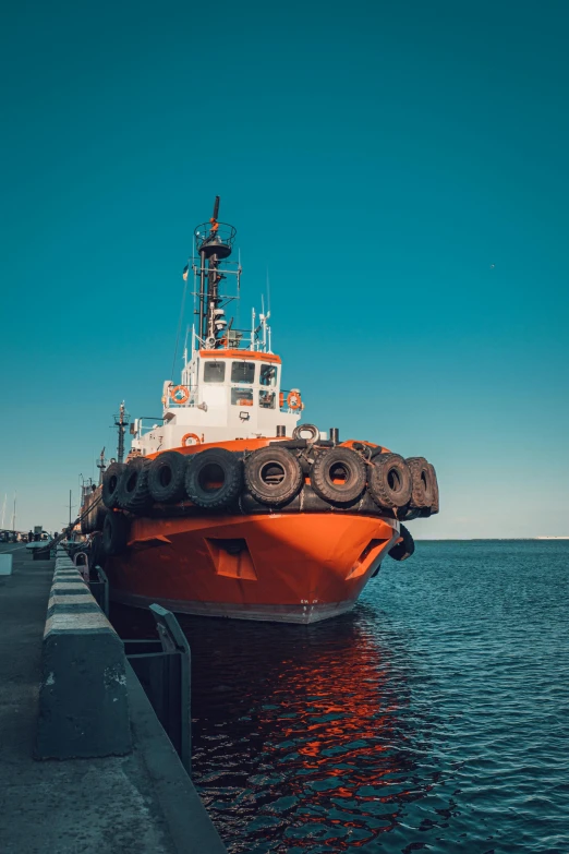 a large orange boat sitting on top of a body of water, a picture, rugged ship captain, 2019 trending photo, industries, beautiful sunny day