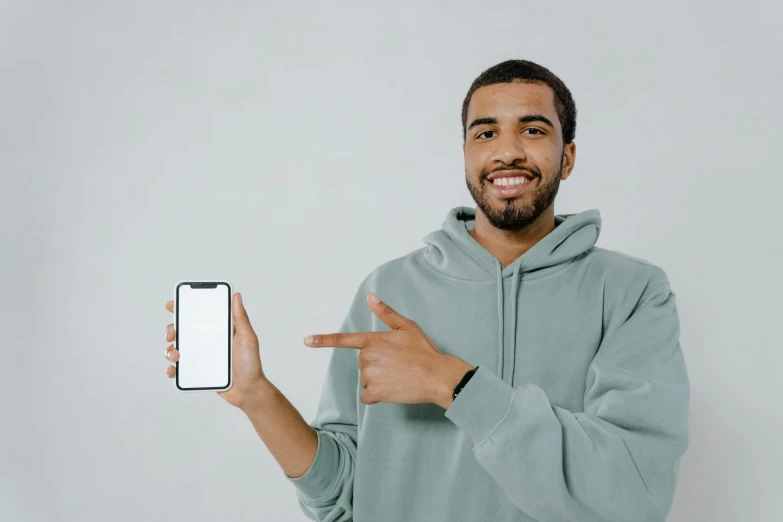 a man in a hoodie holding up a smart phone, a photo, trending on pexels, pixel art, smiling for the camera, white background : 3, iphone 13, product advertising