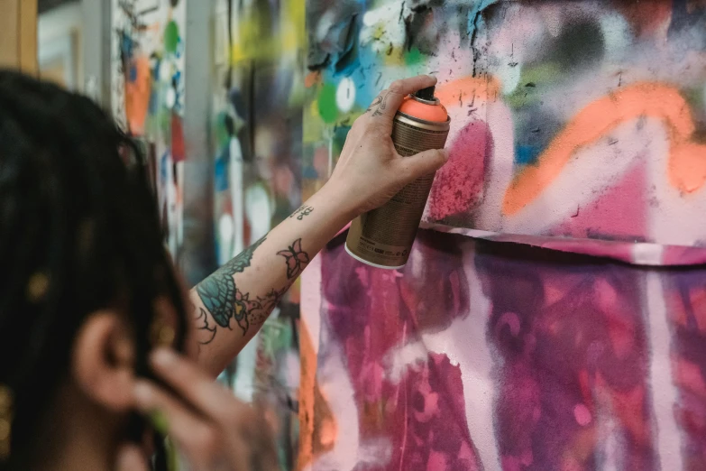 a woman spraying graffiti on a wall with a spray can, trending on pexels, graffiti, photograph of a sleeve tattoo, multicoloured, on a canva, set photo