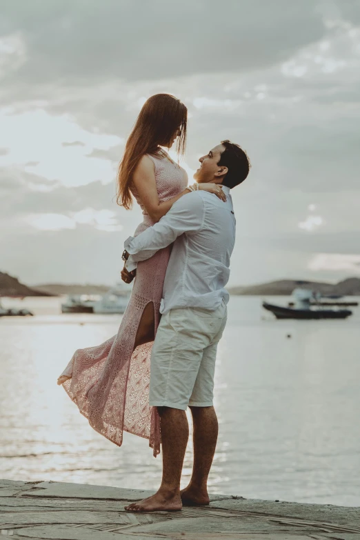 a man and woman standing on a dock next to a body of water, swashbuckling and romantic, instagram post, woman, coastal