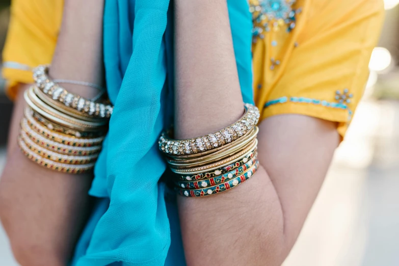 a close up of a person wearing a blue scarf, pexels, arabesque, bangles, yellow and blue and cyan, indian, south east asian with long