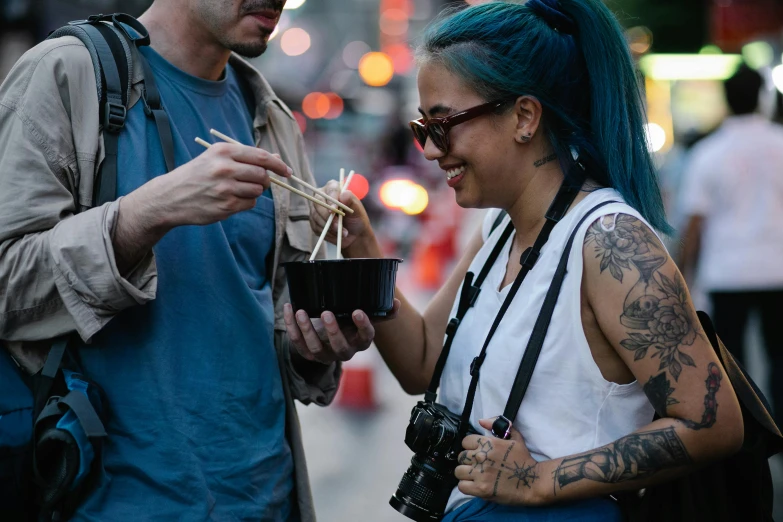 a man and woman standing next to each other holding chopsticks, a photo, by Meredith Dillman, pexels contest winner, of taiwanese girl with tattoos, eating ramen, humans of new york style, short blue haired woman