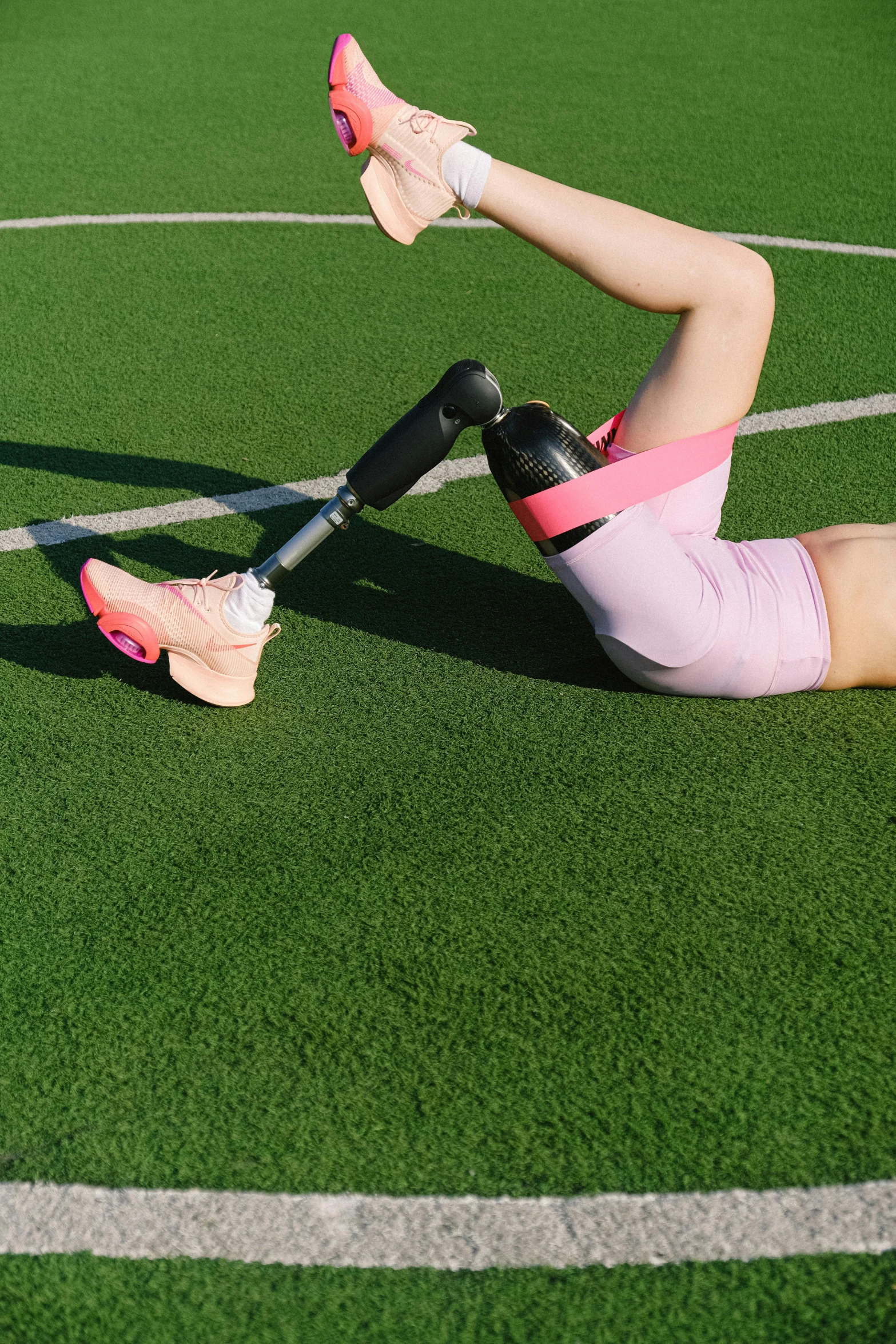 a woman laying on the ground with a tennis racket, a digital rendering, dribble, one legged amputee, stretching her legs on the grass, promo image, exoskeletton