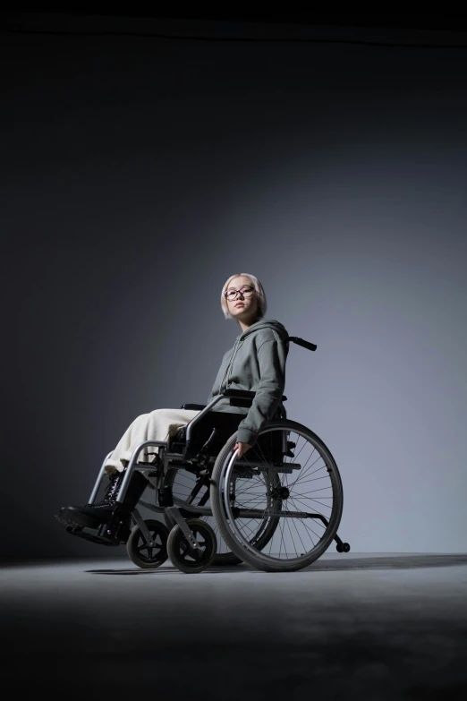 a woman in a wheelchair in a dark room, by Kim Tschang Yeul, hyperrealism, digital photo, plain background, high quality image, portrait of tall