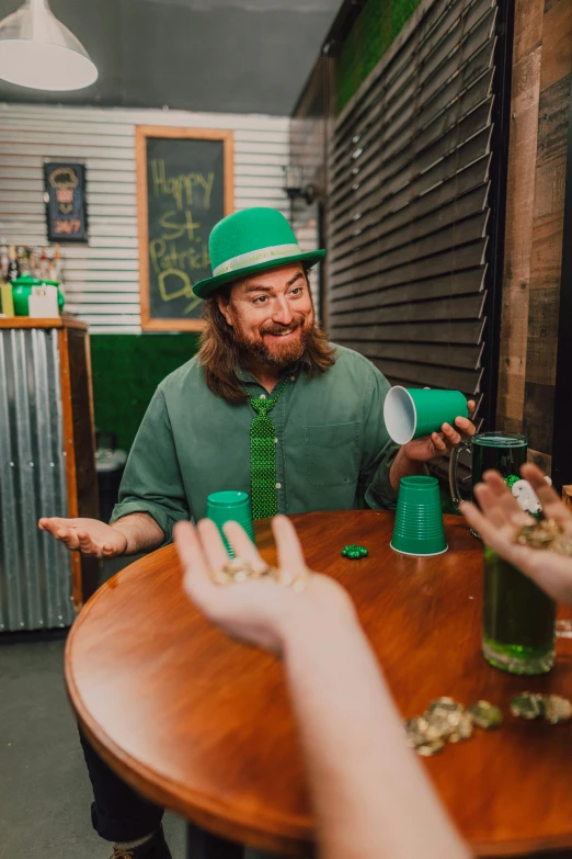 a group of people sitting around a wooden table, wearing green tophat, cheers, dustin lefevre, green robe