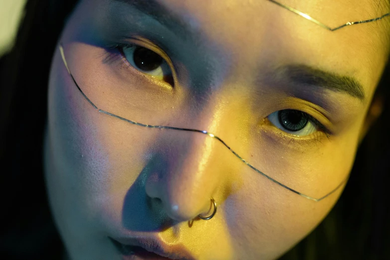a close up of a woman with lines on her face, inspired by Rudolf Hausner, trending on pexels, cai xukun, hong june hyung, futuristic yellow lens, piercing
