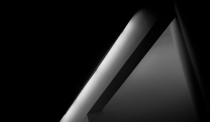 a black and white photo of a corner of a building, inspired by Edward Weston, light and space, black oled background, spaceship hull texture, ceiling fluorescent lighting, monochrome:-2