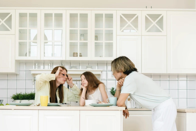 a woman standing next to two girls in a kitchen, trending on pexels, husband wife and son, arguing, white kitchen table, profile image