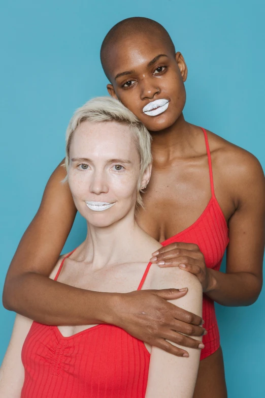 two women posing for a picture in front of a blue background, inspired by Vanessa Beecroft, plush lips, with a white complexion, pride month, on white background