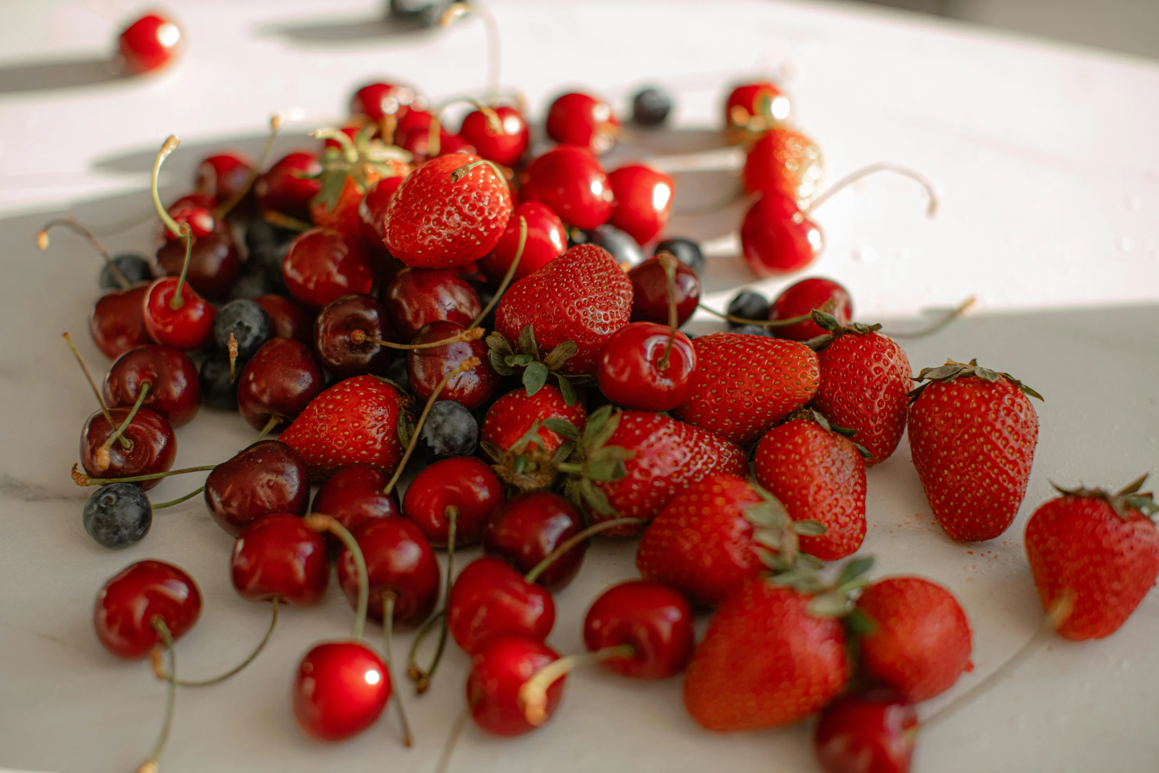 a white plate topped with strawberries and blueberries, a still life, by Julian Hatton, unsplash, cherry trees, red hoods, different sizes, red tones