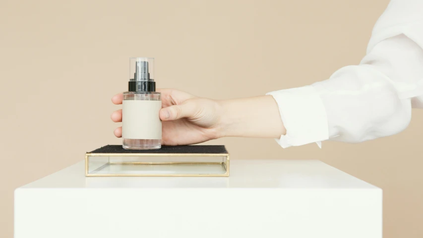 a person holding a bottle on top of a table, a picture, beige mist, full product shot, soft white rubber, ground mist