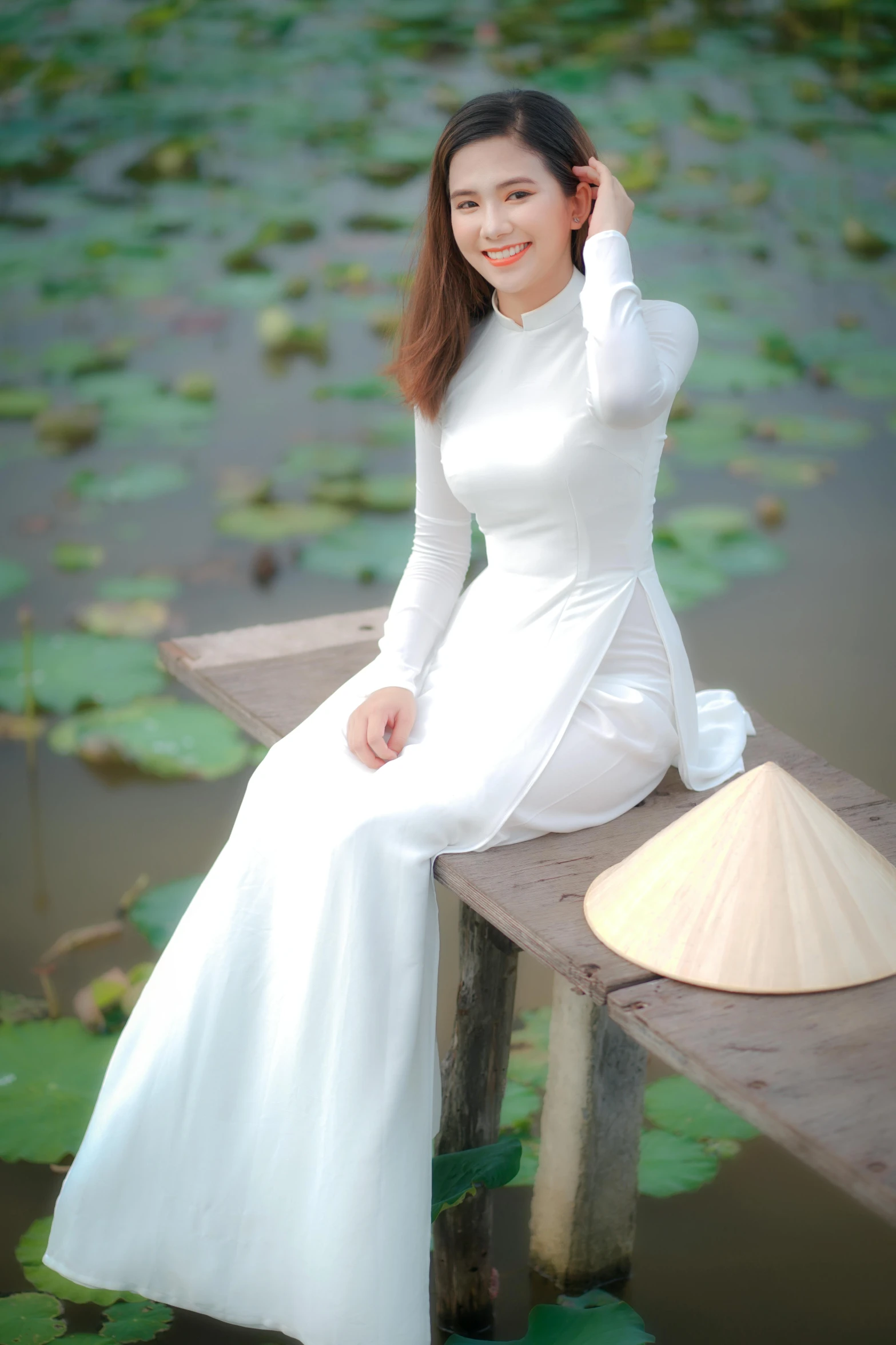 a woman in a white dress sitting on a wooden bridge, inspired by Tan Ting-pho, happening, ao dai, standing on a lotus, low quality photo, square