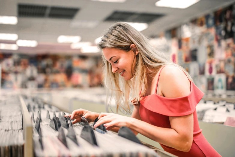 a woman looking at cds in a record store, trending on pexels, beautiful and smiling, avatar image, photo of margot robbie, customers