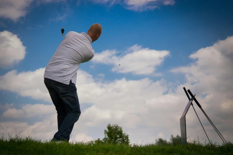 a man standing on top of a lush green field, clubs, ready to strike, amateur photograph, thumbnail