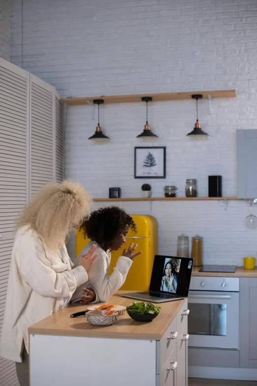 a couple of women standing in a kitchen, a picture, trending on pexels, using a macbook, avatar image, afro tech, having a snack