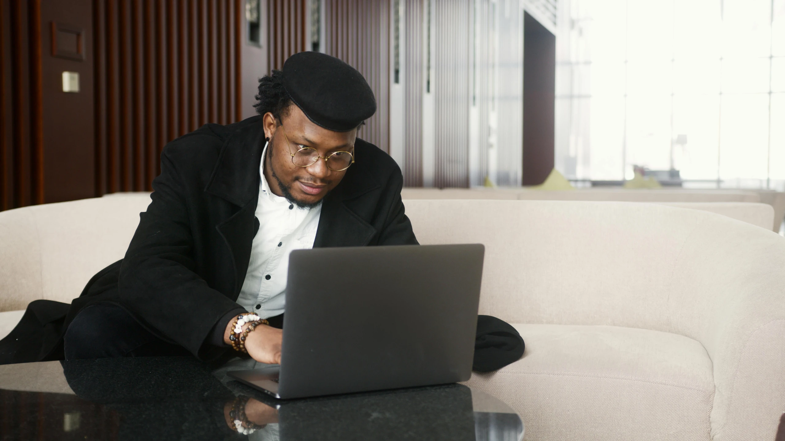 a man sitting on a couch using a laptop, pexels, renaissance, black people, official screenshot, elegantly dressed, post graduate