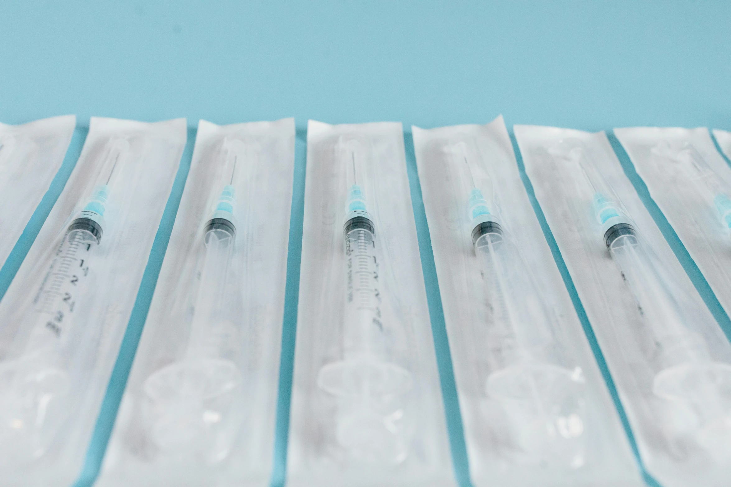 a row of sylls sitting on top of a table, by Ryan Pancoast, pexels, plasticien, surgical iv bag, white cyan, packaging, syringe